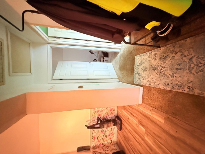 Hallway featuring attic access and wood finished floors