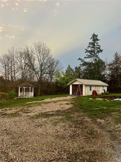 View of yard with an outbuilding, driveway, and a gazebo