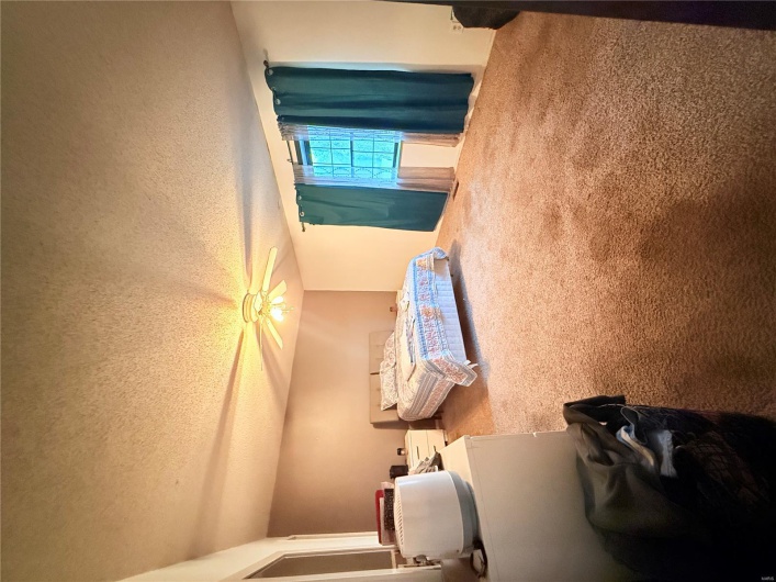 Carpeted bedroom featuring a textured ceiling and ceiling fan