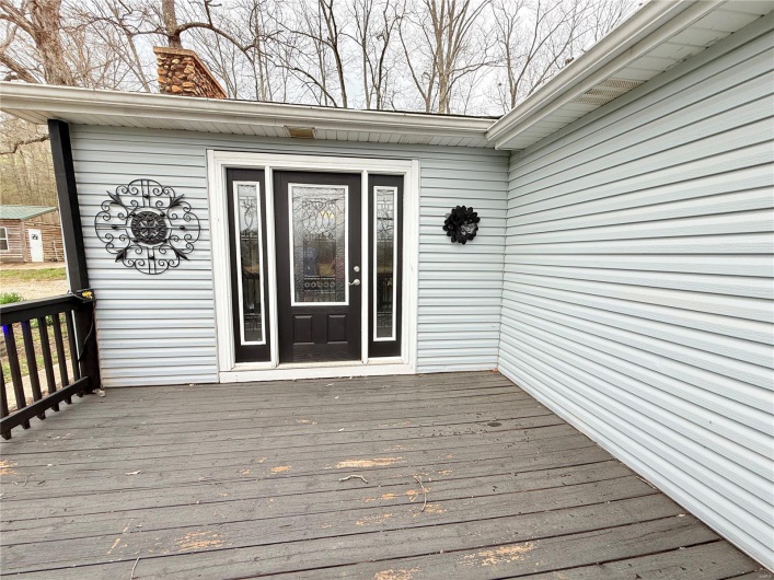 Entrance to property with a wooden deck and a chimney