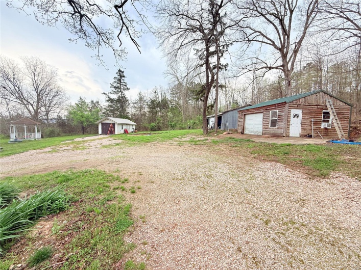 View of yard featuring an outdoor structure, dirt driveway, and a garage