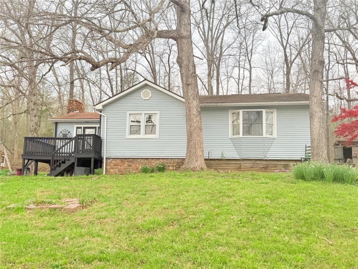 Back of property with stairway, a wooden deck, and a yard