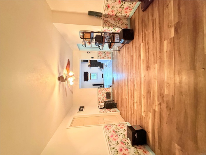 Living area with a ceiling fan, wood finished floors, and baseboards