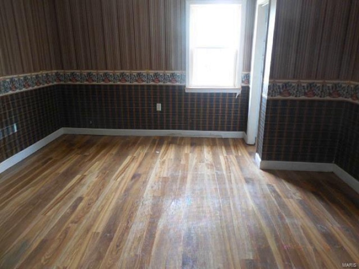 Bedroom featuring wood finished floors and a wainscoted wall