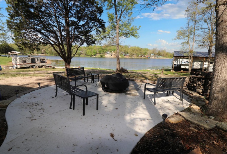 View of patio with a water view and a fire pit
