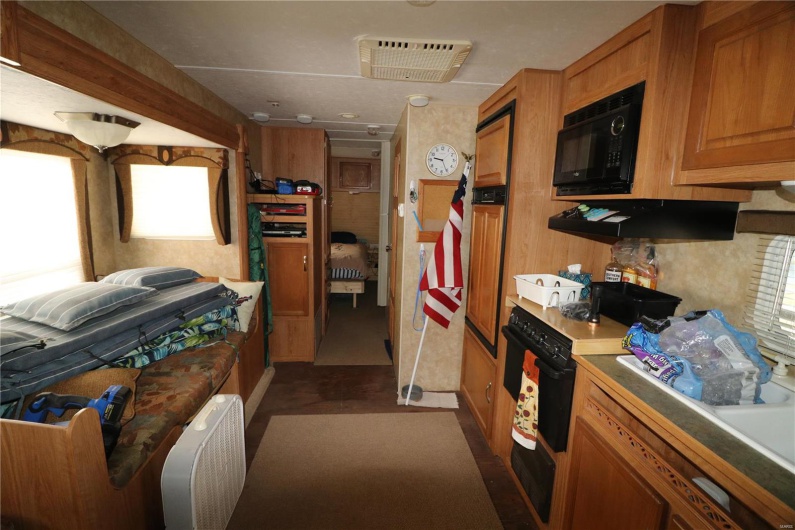 Kitchen featuring brown cabinets, visible vents, and black appliances