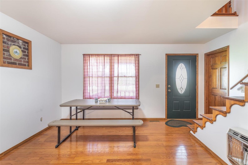 Entryway featuring light wood-style flooring, stairway, baseboards, and heating unit