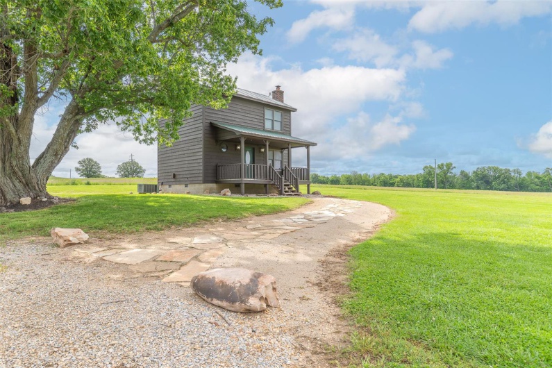 View of grassy yard with a porch and cooling unit