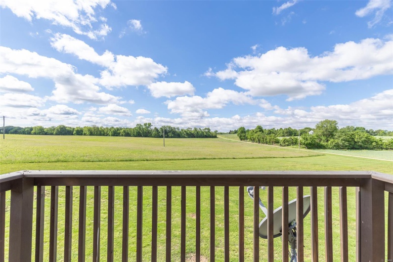 Wooden deck with a rural view and a lawn