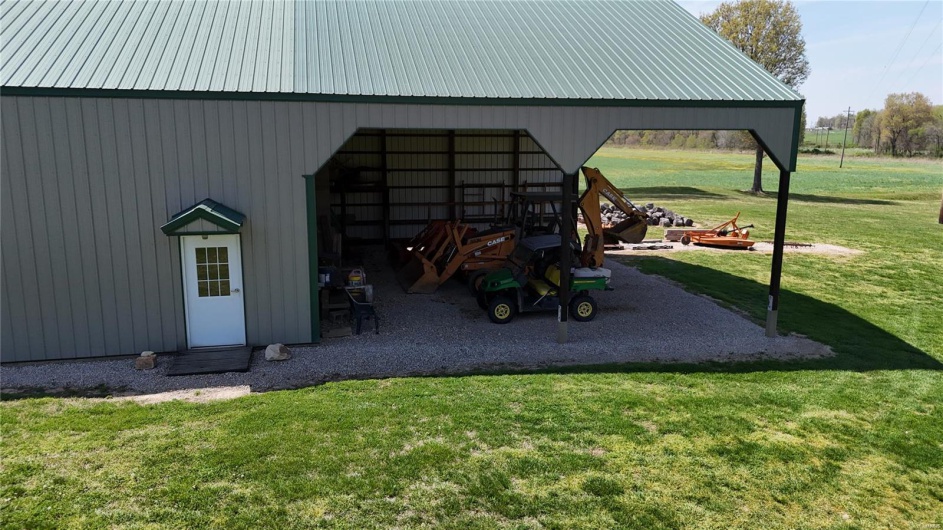 View of pole building with a yard