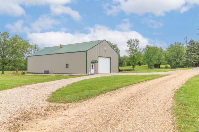 View of pole building with a yard and driveway