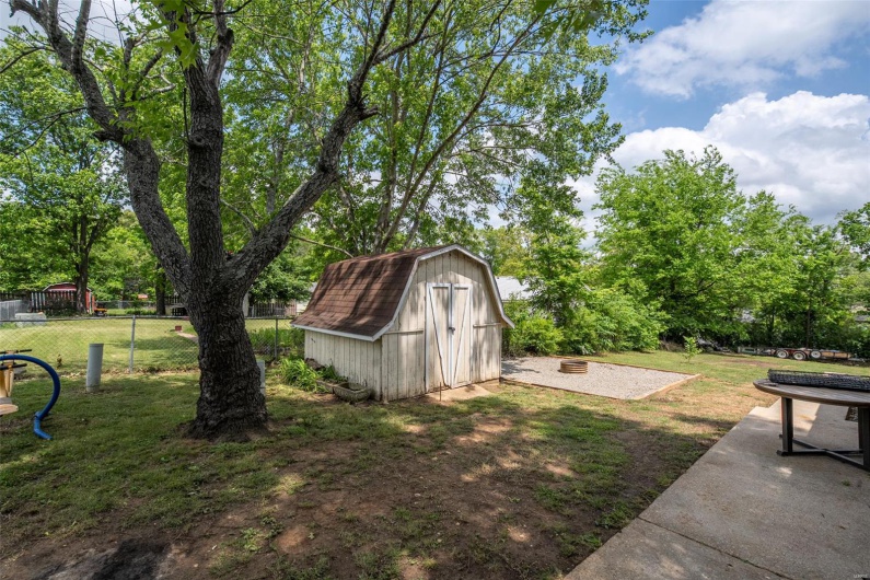 View of yard featuring a shed, an outbuilding, and fence