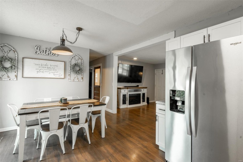 Dining area featuring baseboards, dark wood finished floors, and a textured ceiling