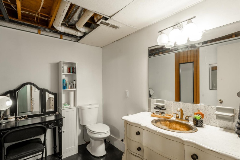 Bathroom featuring toilet, visible vents, and vanity