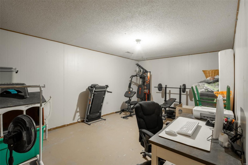 Office space featuring a textured ceiling and finished concrete flooring