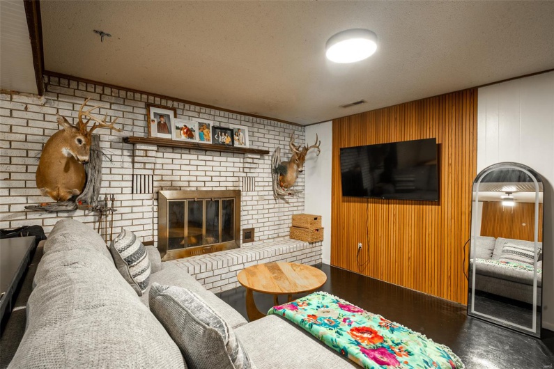 Living area with a fireplace, a textured ceiling, and visible vents