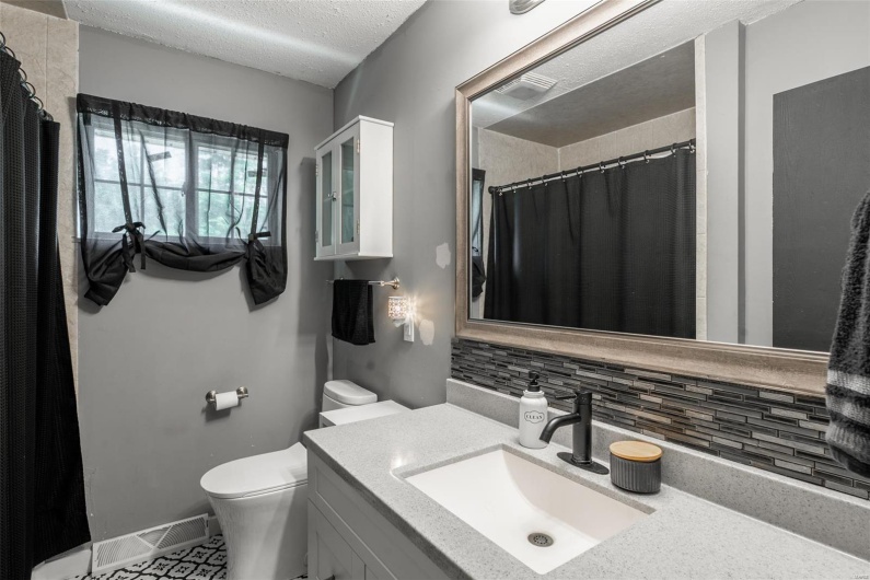 Bathroom with visible vents, vanity, toilet, a textured ceiling, and backsplash
