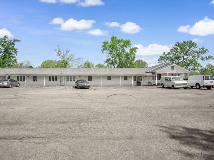 View of building exterior featuring uncovered parking