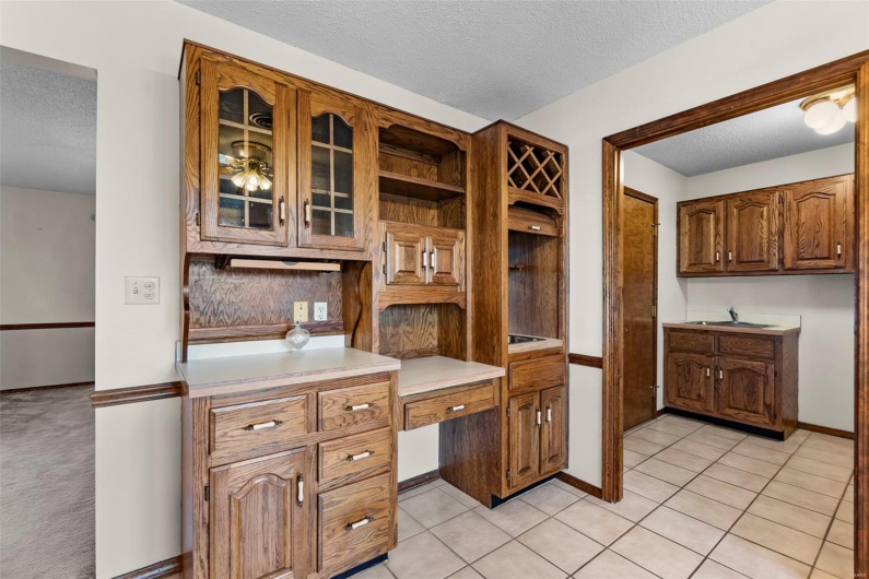 Kitchen featuring light countertops, a textured ceiling, built in study area, and open shelves
