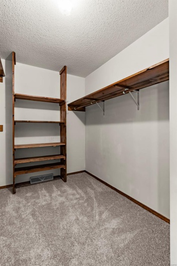 Huge walk in closet in primary bedroom with built-in shelving