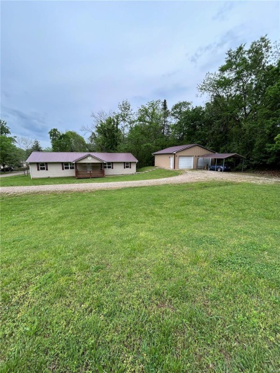 Manufactured / mobile home featuring driveway, a front yard, and a garage
