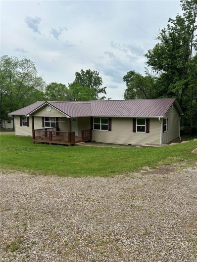 Ranch-style house with a front yard and metal roof