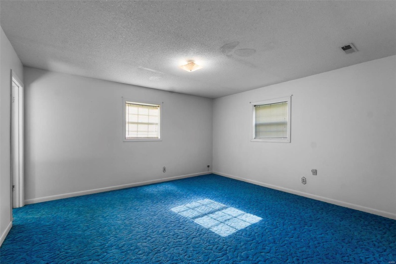 Unfurnished room featuring carpet floors, a textured ceiling, visible vents, and baseboards