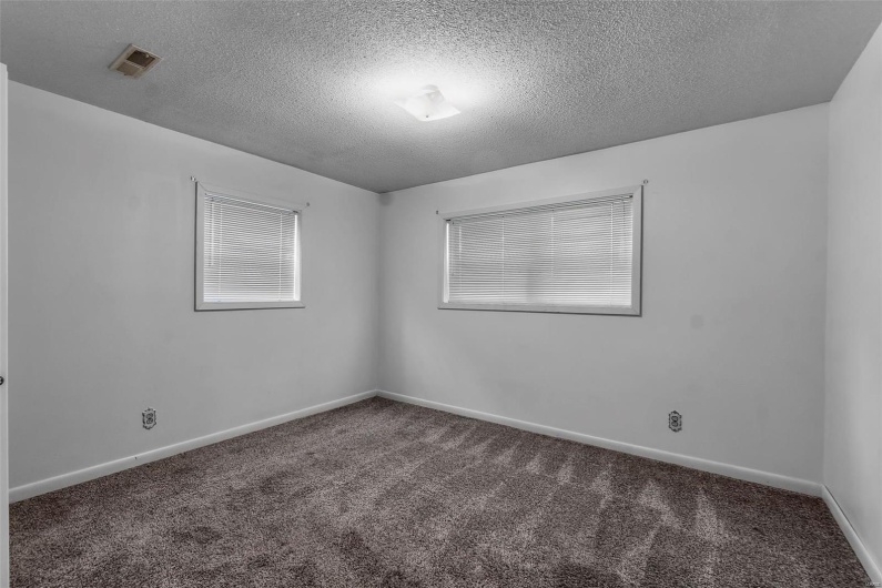 Spare room with carpet floors, a textured ceiling, and baseboards