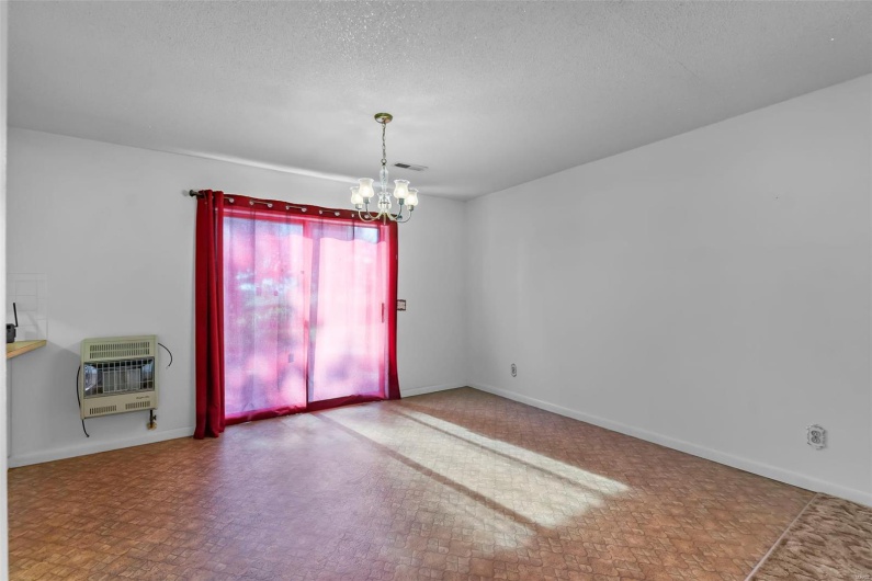 Unfurnished dining area featuring a textured ceiling, visible vents, baseboards, a chandelier, and heating unit