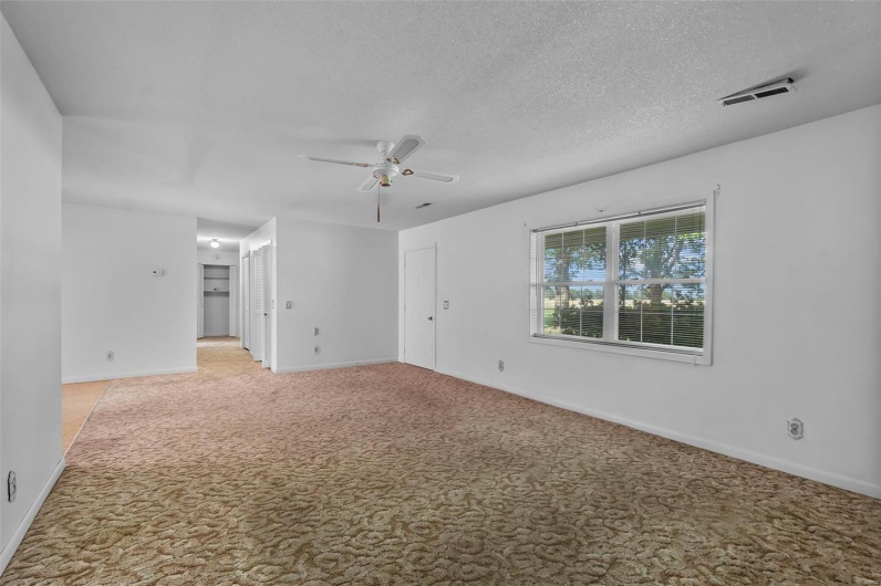 Unfurnished room featuring baseboards, ceiling fan, and light colored carpet