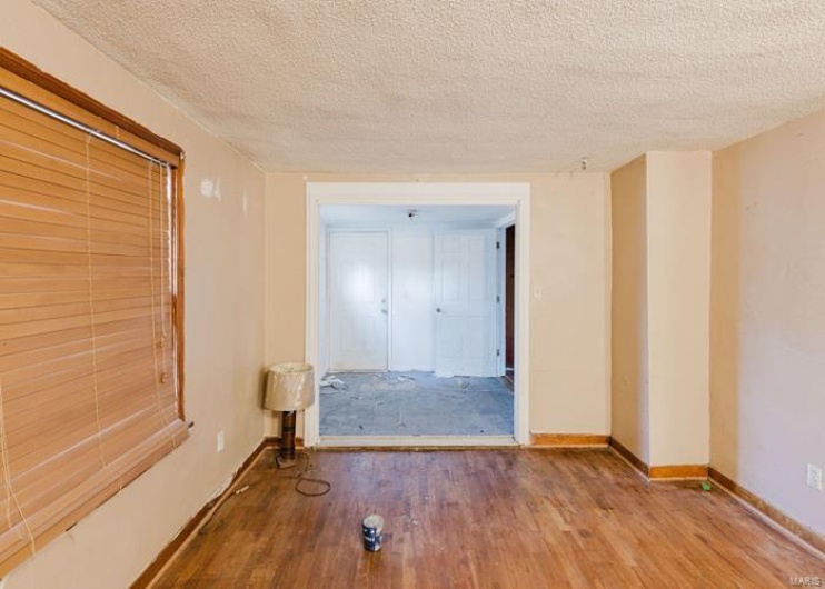 Unfurnished room featuring baseboards, a textured ceiling, and wood finished floors