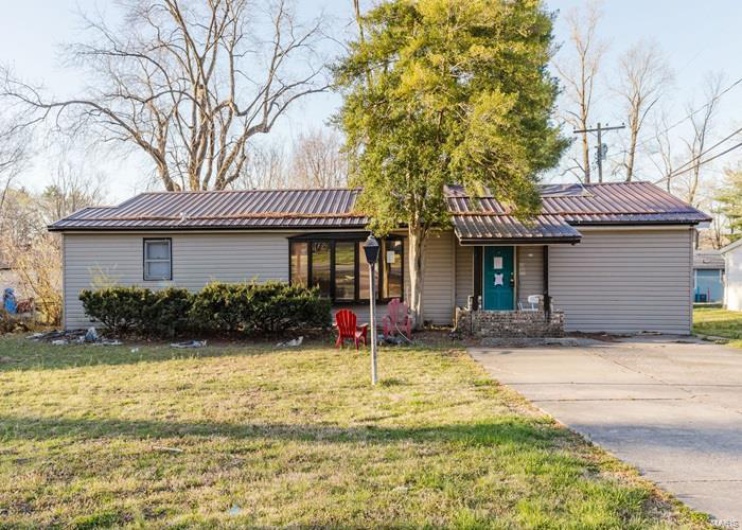 Single story home with a front lawn and metal roof