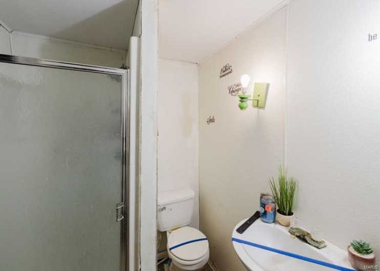 Full bathroom with a stall shower and toilet