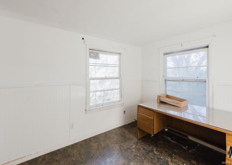 Unfurnished office featuring wainscoting and a wealth of natural light