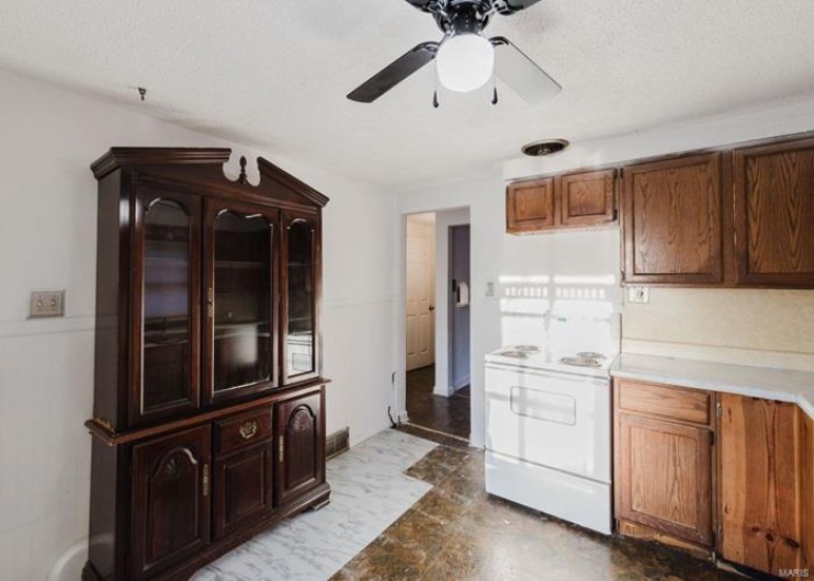 Kitchen with light countertops, a ceiling fan, white electric stove, and marble finish floor