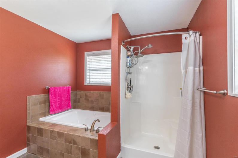 Full bath featuring a garden tub and a shower with shower curtain
