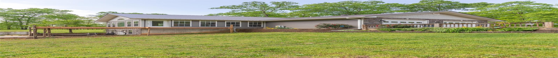 Residential For Sale View of front of house with an attached garage, metal roof, and a front yard