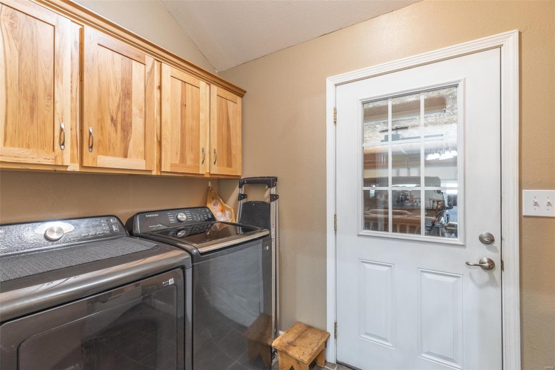 Washroom with washer and clothes dryer and cabinet space