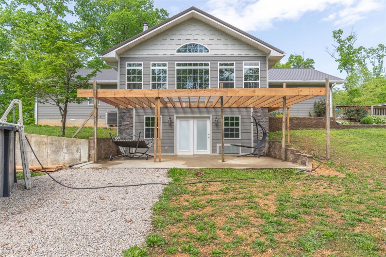 Rear view of property with a patio, a yard, a pergola, and fence