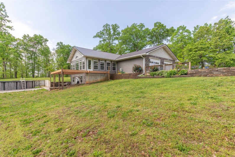 Rear view of property featuring a lawn and a deck