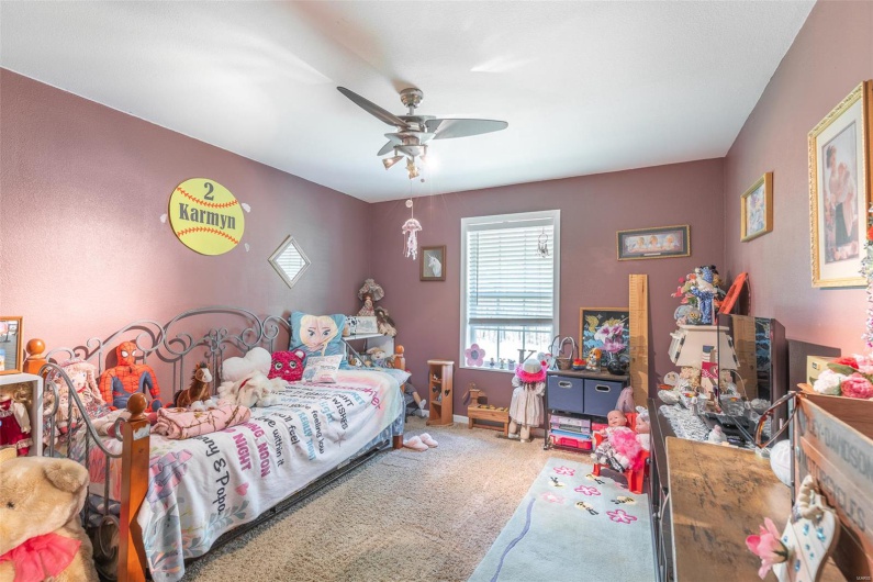 Carpeted bedroom with a ceiling fan