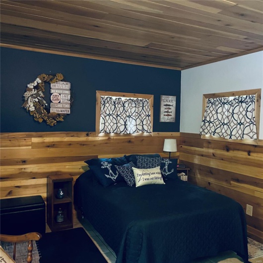 Bedroom with wood ceiling and wooden walls