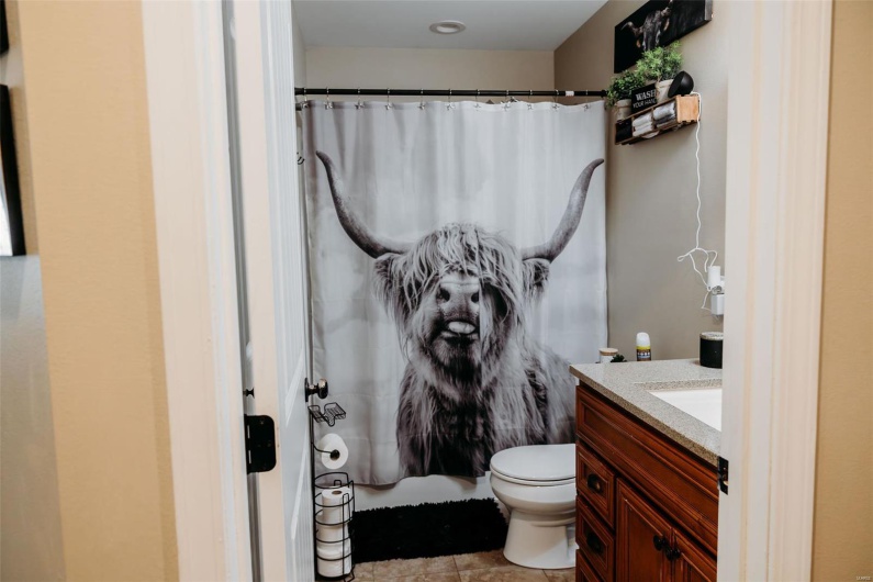 Bathroom featuring vanity, tile patterned floors, curtained shower, and toilet