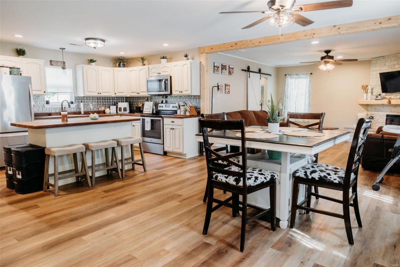Dining room with a ceiling fan, a wealth of natural light, and light wood-style flooring