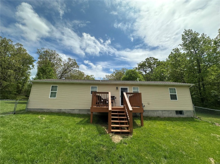 Back of property with a lawn, backyard, and a deck