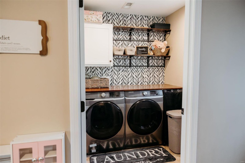 Laundry room featuring cabinet space, visible vents, and washer and clothes dryer