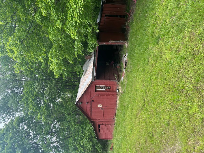 View of pole building with a yard