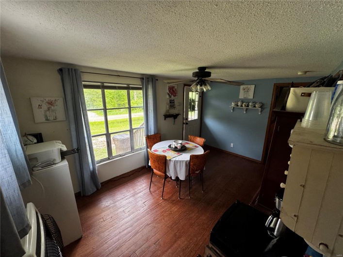 Dining area with a textured ceiling, wood finished floors, and ceiling fan