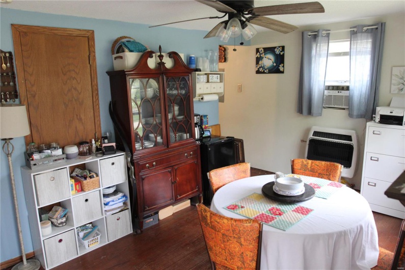 Dining space featuring cooling unit, heating unit, dark wood-style floors, and a ceiling fan