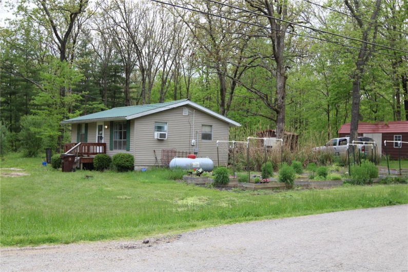 View of home's exterior featuring metal roof and a lawn